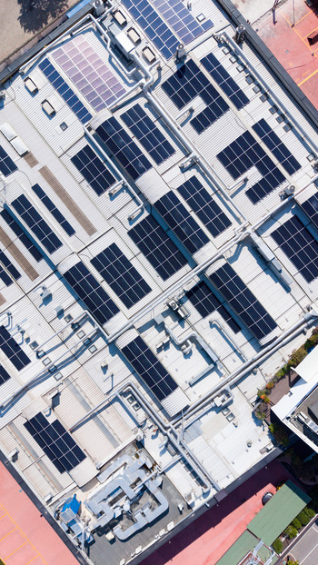 Aerial view of an industrial building roof featuring extensive solar panel arrays metal roofing and HVAC ventilation systems in Milan Lombardy Italy. Aerial view of an industrial building roof featuring extensive solar panel arrays metal roofing and HVAC ventilation systems in Milan Lombardy Italy.
