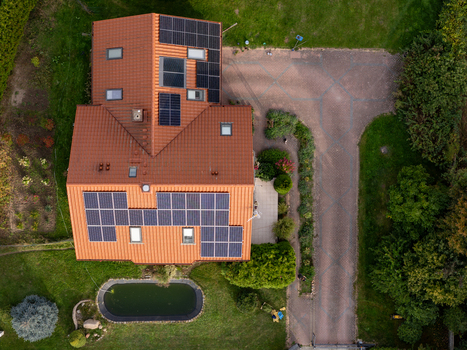 Aerial view of a residential house with solar panels on the roof a driveway and a small pond in the garden in Gdansk Poland. Aerial view of a residential house with solar panels on the roof a driveway and a small pond in the garden in Gdansk Poland.