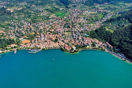 Aerial view of the town of Garda nestled along the turquoise shores of Lake Garda with its historic buildings and surrounding green hills in Garda Veneto Italy. Aerial view of the town of Garda nestled along the turquoise shores of Lake Garda with its historic buildings and surrounding green hills in Garda Veneto Italy.
