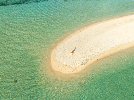 Aerial view of Malcapuya Island featuring a pristine white sandbar surrounded by crystal clear turquoise water with a person standing on the sand Coron Mimaropa Philippines. Aerial view of Malcapuya Island featuring a pristine white sandbar surrounded by crystal clear turquoise water with a person standing on the sand Coron Mimaropa Philippines.