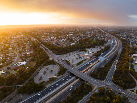 Aerial view of Mitchell Freeway interchange surrounded by suburban residential areas and greenery during golden hour in Perth Western Australia Australia. Aerial view of Mitchell Freeway interchange surrounded by suburban residential areas and greenery during golden hour in Perth Western Australia Australia.
