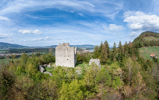 Aerial view of the historic ruins of Burg Montsalvens surrounded by lush green forests and rolling hills in Broc Fribourg Switzerland. Aerial view of the historic ruins of Burg Montsalvens surrounded by lush green forests and rolling hills in Broc Fribourg Switzerland.