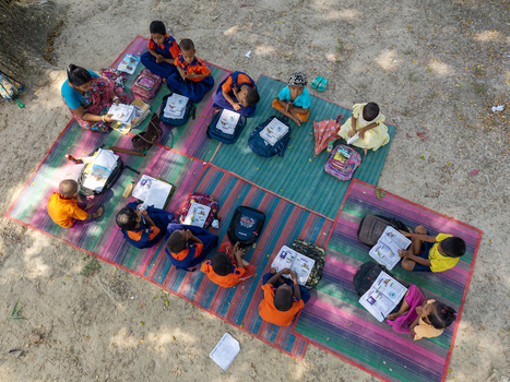 Joypurhat Bangladesh 22 September 2026 Aerial view of children sitting on colorful mats outdoors studying with their teacher under the shade of a tree. Joypurhat Bangladesh 22 September 2026 Aerial view of children sitting on colorful mats outdoors studying with their teacher under the shade of a tree.