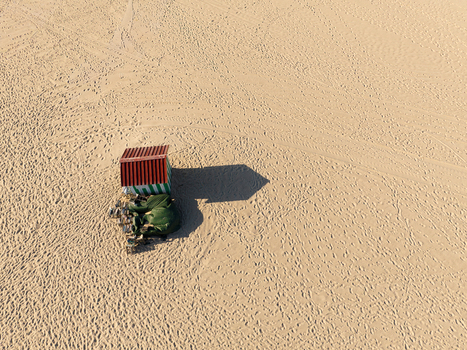 Aerial view of a striped beach hut with a red roof casting a long shadow on the vast sandy expanse of Praia do Relogio at Figueira da Foz Coimbra District Portugal.