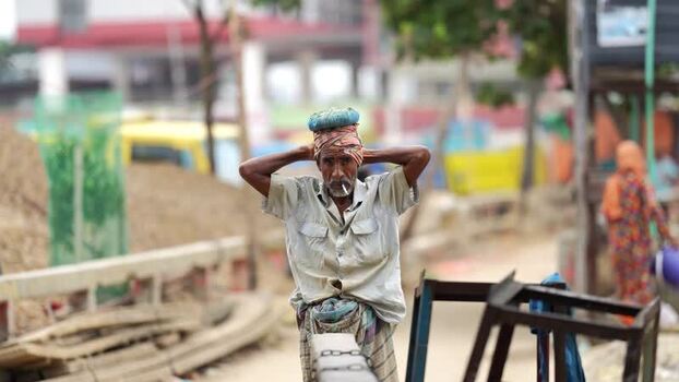View of a laborer standing in Aminbazar Bangladesh. View of a laborer standing in Aminbazar Bangladesh.