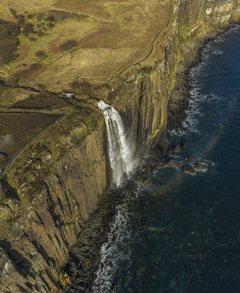 Aerial view of Mealt Falls cascading down the basalt cliffs of Kilt Rock into the ocean Isle of Skye Scotland United Kingdom. Aerial view of Mealt Falls cascading down the basalt cliffs of Kilt Rock into the ocean Isle of Skye Scotland United Kingdom.