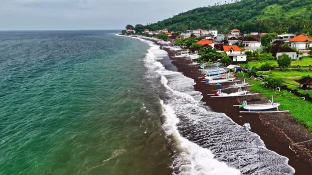 Aerial view of black sand beach with traditional boats Indonesia.