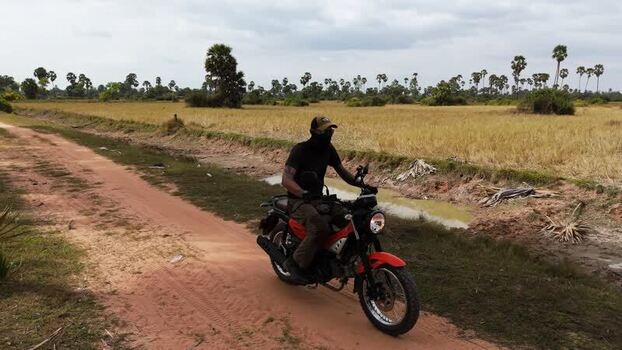 Aerial view of motorcyclist on a rural dirt path Cambodia. Aerial view of motorcyclist on a rural dirt path Cambodia.