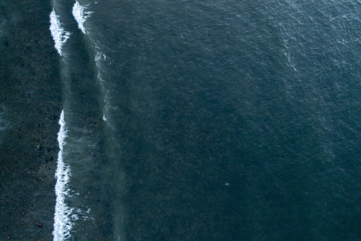 Aerial view of ocean waves gently crashing against the rocky shoreline in Sayulita Nayarit Mexico. Aerial view of ocean waves gently crashing against the rocky shoreline in Sayulita Nayarit Mexico.