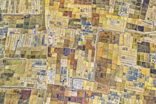 Aerial view of geometric fields create a captivating patchwork of earthy browns pale yellows and muted greens Cox s Bazar Chittagong Division Bangladesh. Aerial view of geometric fields create a captivating patchwork of earthy browns pale yellows and muted greens Cox s Bazar Chittagong Division Bangladesh.