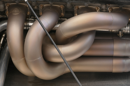 Chichester United Kingdom 21 July 2018 View of the exhaust manifold with its complex curves and metallic sheen reflecting light and heat in a symphony of engineering precision. Chichester United Kingdom 21 July 2018 View of the exhaust manifold with its complex curves and metallic sheen reflecting light and heat in a symphony of engineering precision.