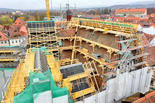 Aerial view of Rathaus Forchheim under renovation with workers on the roof and extensive scaffolding among historic town rooftops in Forchheim Bayern Germany. Aerial view of Rathaus Forchheim under renovation with workers on the roof and extensive scaffolding among historic town rooftops in Forchheim Bayern Germany.
