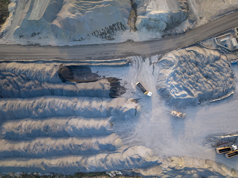 Aerial view of a quarry site with large piles of gravel heavy dump trucks operating on dirt paths and industrial earthmoving equipment in Istanbul Istanbul Turkiye.