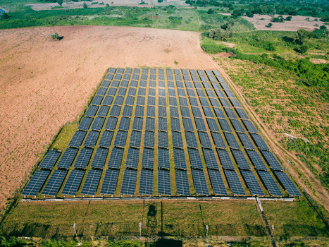 Aerial view of a large solar farm with rows of photovoltaic panels installed in a rural landscape in Ogun State Nigeria.