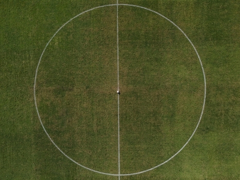 Aerial view of the center circle on the green grass pitch at Maguwoharjo Stadium in Kecamatan Depok Daerah Istimewa Yogya Indonesia.