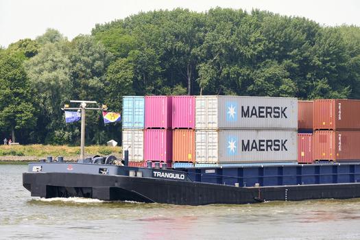 Dordrecht South Holland Netherlands 31 May 2026 View of the container ship Tranquilo carrying colorful Maersk containers along the Oude Maas river with green trees in the background.