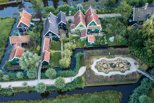 Zaandam Netherlands 26 July 2026 Aerial view of traditional green wooden houses and a manicured garden surrounded by canals.