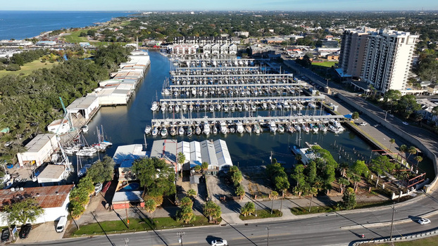 Aerial view of the Lake Pontchartrain shoreline featuring a marina filled with sailboats and yachts surrounded by coastal buildings and greenery in Jefferson Parish Louisiana United States.