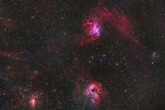 View of the vibrant Flaming Star and Tadpole Nebulae glowing in the deep space of the night sky over Poland. View of the vibrant Flaming Star and Tadpole Nebulae glowing in the deep space of the night sky over Poland.
