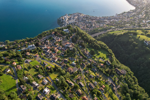 Aerial view of the village of Glion situated on the hillside overlooking Lake Geneva with residential houses lush green slopes and the town of Montreux in Montreux Vaud Switzerland. Aerial view of the village of Glion situated on the hillside overlooking Lake Geneva with residential houses lush green slopes and the town of Montreux in Montreux Vaud Switzerland.