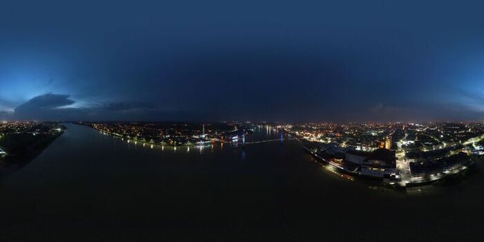 Aerial view of Seberang Kota at night with city lights reflecting on the river illuminated bridge and dark sky in Seberang Kota Jambi Indonesia. Aerial view of Seberang Kota at night with city lights reflecting on the river illuminated bridge and dark sky in Seberang Kota Jambi Indonesia.