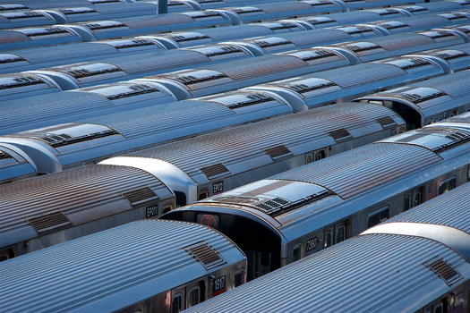 View of subway train cars parked in a rail yard with corrugated metal roofs and side windows New York New York United States. View of subway train cars parked in a rail yard with corrugated metal roofs and side windows New York New York United States.