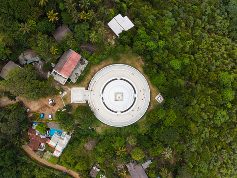 Aerial view of the Japanese Peace Pagoda Rumassala surrounded by lush tropical forest and nearby buildings in Unawatuna Southern Province Sri Lanka. Aerial view of the Japanese Peace Pagoda Rumassala surrounded by lush tropical forest and nearby buildings in Unawatuna Southern Province Sri Lanka.