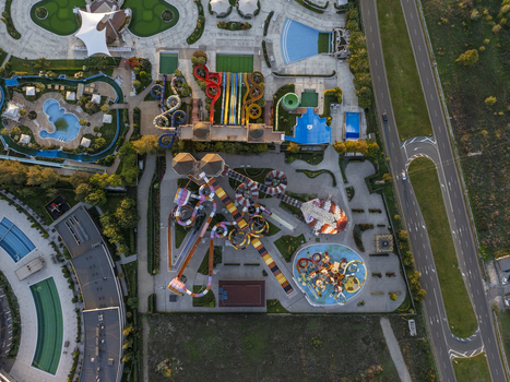 Aerial view of a vibrant water park featuring colorful winding slides multiple swimming pools and paved walkways in Bulgaria. Aerial view of a vibrant water park featuring colorful winding slides multiple swimming pools and paved walkways in Bulgaria.