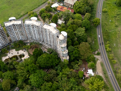Aerial view of the Sonesta One Resort complex surrounded by dense tropical forest and a winding coastal road in Jaco Provincia de Puntarenas Costa Rica. Aerial view of the Sonesta One Resort complex surrounded by dense tropical forest and a winding coastal road in Jaco Provincia de Puntarenas Costa Rica.