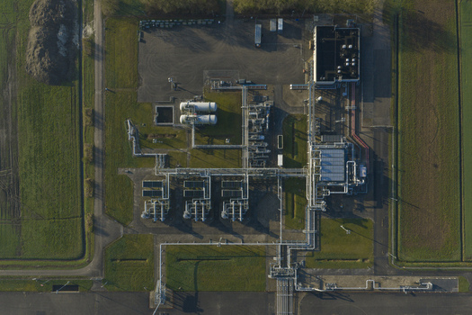 Aerial view of the natural gas mining facility with its network of pipes storage tanks and industrial buildings surrounded by green fields in Slochteren Groningen Netherlands. Aerial view of the natural gas mining facility with its network of pipes storage tanks and industrial buildings surrounded by green fields in Slochteren Groningen Netherlands.