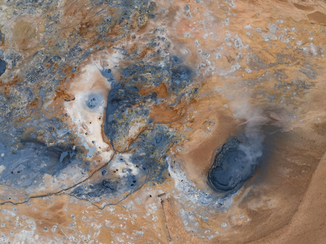 Aerial view of Hverir geothermal area showing bubbling mud pools steaming fumaroles and vibrant mineral rich earth in Reykjahlid Thingeyjarsveit Iceland. Aerial view of Hverir geothermal area showing bubbling mud pools steaming fumaroles and vibrant mineral rich earth in Reykjahlid Thingeyjarsveit Iceland.