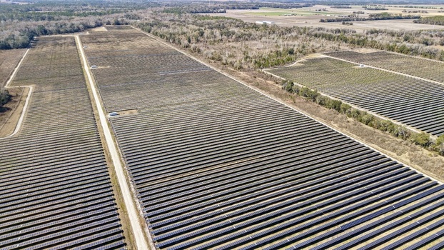 Aerial view of vast solar panel arrays stretching across the landscape under a clear sky juxtaposed with patches of bare earth Elkton Florida United States. Aerial view of vast solar panel arrays stretching across the landscape under a clear sky juxtaposed with patches of bare earth Elkton Florida United States.