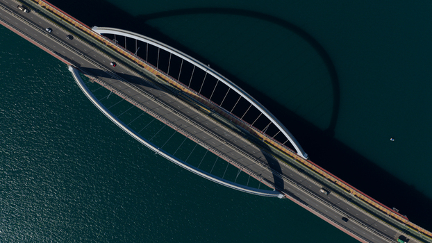 Aerial view of the Cross Bay Link bridge with its distinctive double arch design and traffic over the blue water Hong Kong Hong Kong.
