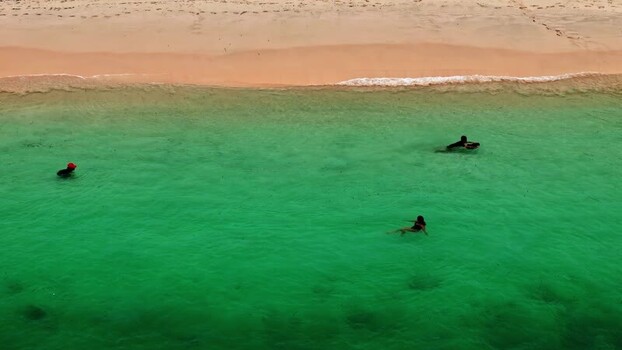 Aerial view of people swimming in turquoise water Indonesia.