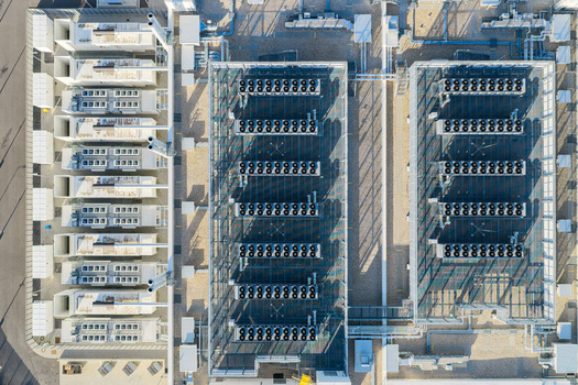 Aerial view of Vantage Data Centers BER1 featuring rows of industrial cooling units and technical infrastructure on the roof in Ludwigsfelde Brandenburg Germany. Aerial view of Vantage Data Centers BER1 featuring rows of industrial cooling units and technical infrastructure on the roof in Ludwigsfelde Brandenburg Germany.