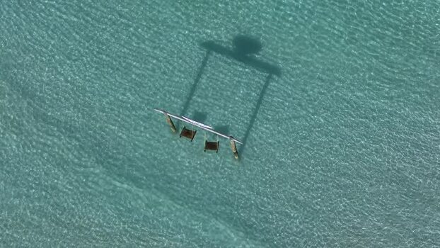 Aerial view of a wooden swing set in turquoise water Maldives. Aerial view of a wooden swing set in turquoise water Maldives.