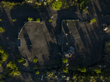 Aerial view of Bunker Kaliadem Merapi surrounded by volcanic soil and sparse greenery with long shadows at sunset Kecamatan Pakem Daerah Istimewa Yogya Indonesia. Aerial view of Bunker Kaliadem Merapi surrounded by volcanic soil and sparse greenery with long shadows at sunset Kecamatan Pakem Daerah Istimewa Yogya Indonesia.