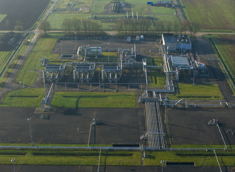 Aerial view of the natural gas mining facility with complex pipelines storage tanks and industrial infrastructure surrounded by rural fields in Slochteren Groningen Netherlands. Aerial view of the natural gas mining facility with complex pipelines storage tanks and industrial infrastructure surrounded by rural fields in Slochteren Groningen Netherlands.