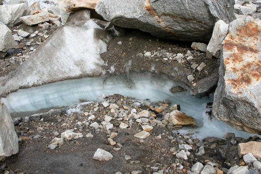 View of Goro II campsite showing glacial ice layers exposed beneath large granite boulders and rocky debris in the mountainous terrain of k2 basecamp trek Gilgit Pakistan. View of Goro II campsite showing glacial ice layers exposed beneath large granite boulders and rocky debris in the mountainous terrain of k2 basecamp trek Gilgit Pakistan.