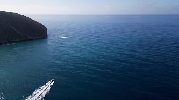 Aerial view of a boat on the sea near the cliffs of Moraira Spain.