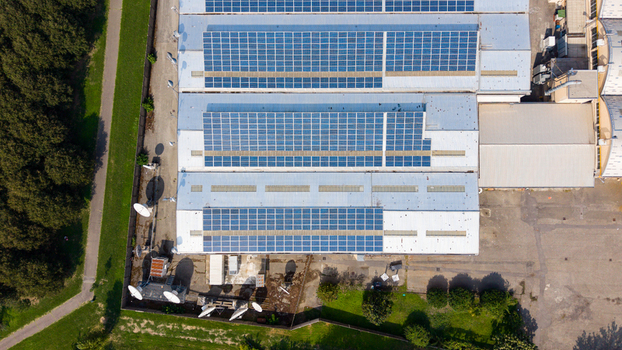 Aerial view of industrial buildings with solar panels on the roof in the industrial zone of Milan Lombardy Italy. Aerial view of industrial buildings with solar panels on the roof in the industrial zone of Milan Lombardy Italy.