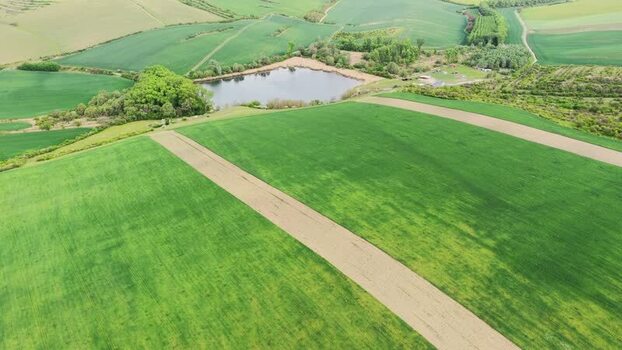 Aerial view of rolling green fields and a small pond Czechia.