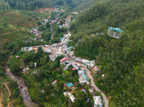 Aerial view of the village nestled in a lush valley with tea plantations dense forests and a winding river in Nallathanniya Central Province Sri Lanka. Aerial view of the village nestled in a lush valley with tea plantations dense forests and a winding river in Nallathanniya Central Province Sri Lanka.