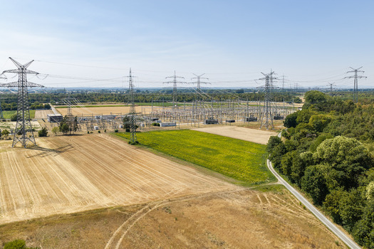 Aerial view of the Amprion Umspannwerk substation surrounded by agricultural fields and power lines in Pfungstadt Hessen Germany.