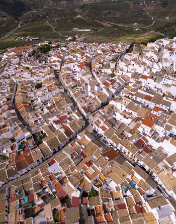 Aerial view of the dense cluster of white washed houses with terracotta rooftops and narrow streets in the historic town of Olvera Andalusia Spain. Aerial view of the dense cluster of white washed houses with terracotta rooftops and narrow streets in the historic town of Olvera Andalusia Spain.