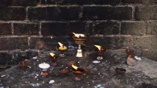 View of burning butter lamps at the sacred site of Lumbini Nepal.