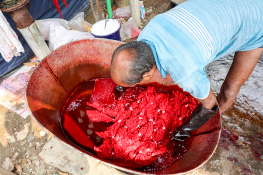 Narayanganj Bangladesh 29 March 2026 View of a man immersed in a vivid tableau of crimson soaked fabrics within a large metal container a stark contrast to the mundane surroundings. Narayanganj Bangladesh 29 March 2026 View of a man immersed in a vivid tableau of crimson soaked fabrics within a large metal container a stark contrast to the mundane surroundings.