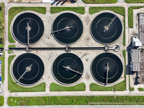 Aerial view of circular sedimentation tanks at the Impianto depurazione water treatment plant surrounded by green grass in Castiglione Torinese Piedmont Italy.