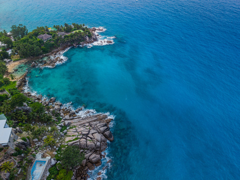 Aerial view of the turquoise ocean embracing the rugged coastline where the land meets the sea Vista do Mar Mahe Island Seychelles. Aerial view of the turquoise ocean embracing the rugged coastline where the land meets the sea Vista do Mar Mahe Island Seychelles.