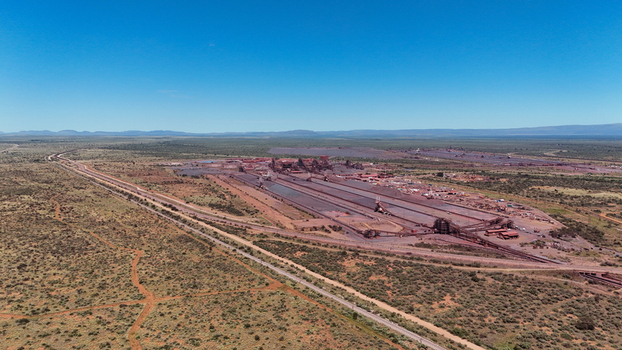 Aerial view of a sprawling mine facility with vast red earth and industrial structures contrasting against the dry green bushveld under a clear blue sky Rustenburg North West South Africa. Aerial view of a sprawling mine facility with vast red earth and industrial structures contrasting against the dry green bushveld under a clear blue sky Rustenburg North West South Africa.